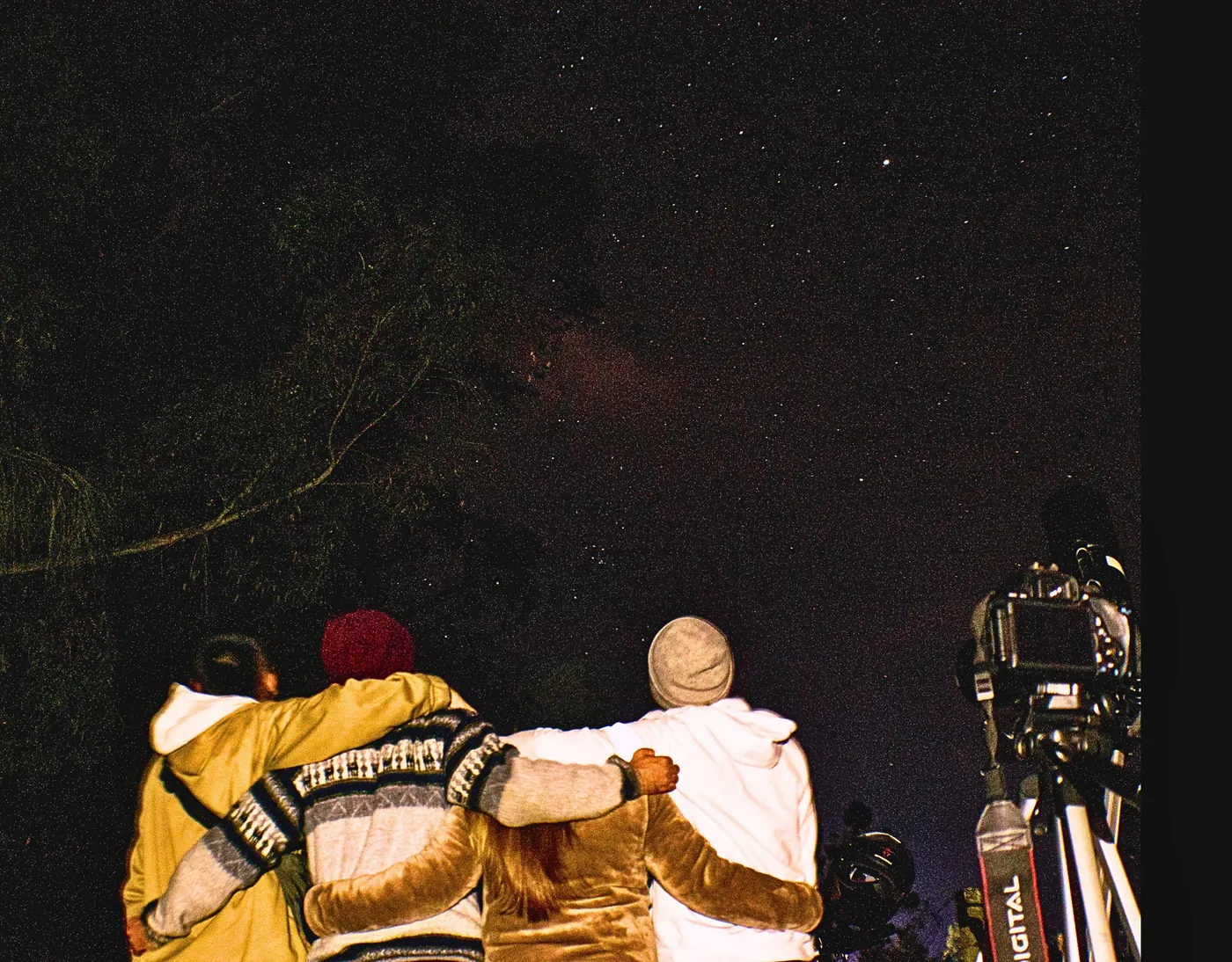 Amigos abrazados junto al telescopio